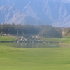 Mountains loom overhead and a waterfall rushes on No. 16.