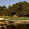 A view of a green surrounded by bunkers and water at Peacock Gap Golf Club
