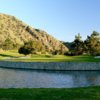 A view of a challenging green surrounded by water at San Dimas Canyon Golf Course.