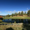 The green on the par-4 ninth hole at Grizzly Ranch Golf Club sits beside a pond.