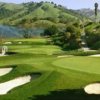 A view of a green guarded by sand traps at Indian Valley Golf Club