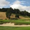 A view of a green surrounded by bunkers at Meadow Club