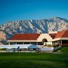 A view of the clubhouse at Desert Dunes Golf Course  with green in foreground