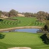 A view of a green with water in background at Catta Verdera Country Club