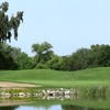 A green view with water in foreground and bunker on the left at Turkey Creek Golf Club
