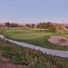 A view of green with bunker on the right and narrow road in foreground at  The SCGA Member's Club at Rancho California