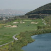 A view of green #10 surrounded by bunkers with water on the right at Oak Quarry Golf Club