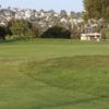 A view of a green and houses in the distance at Mission Bay Golf Course.