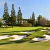A sunny day view of a hole surrounded by a collection of bunkers at Wilshire Country Club.