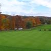 A fall day view of the practice putting green and a fairway in the distance at Seven Oaks Country Club.